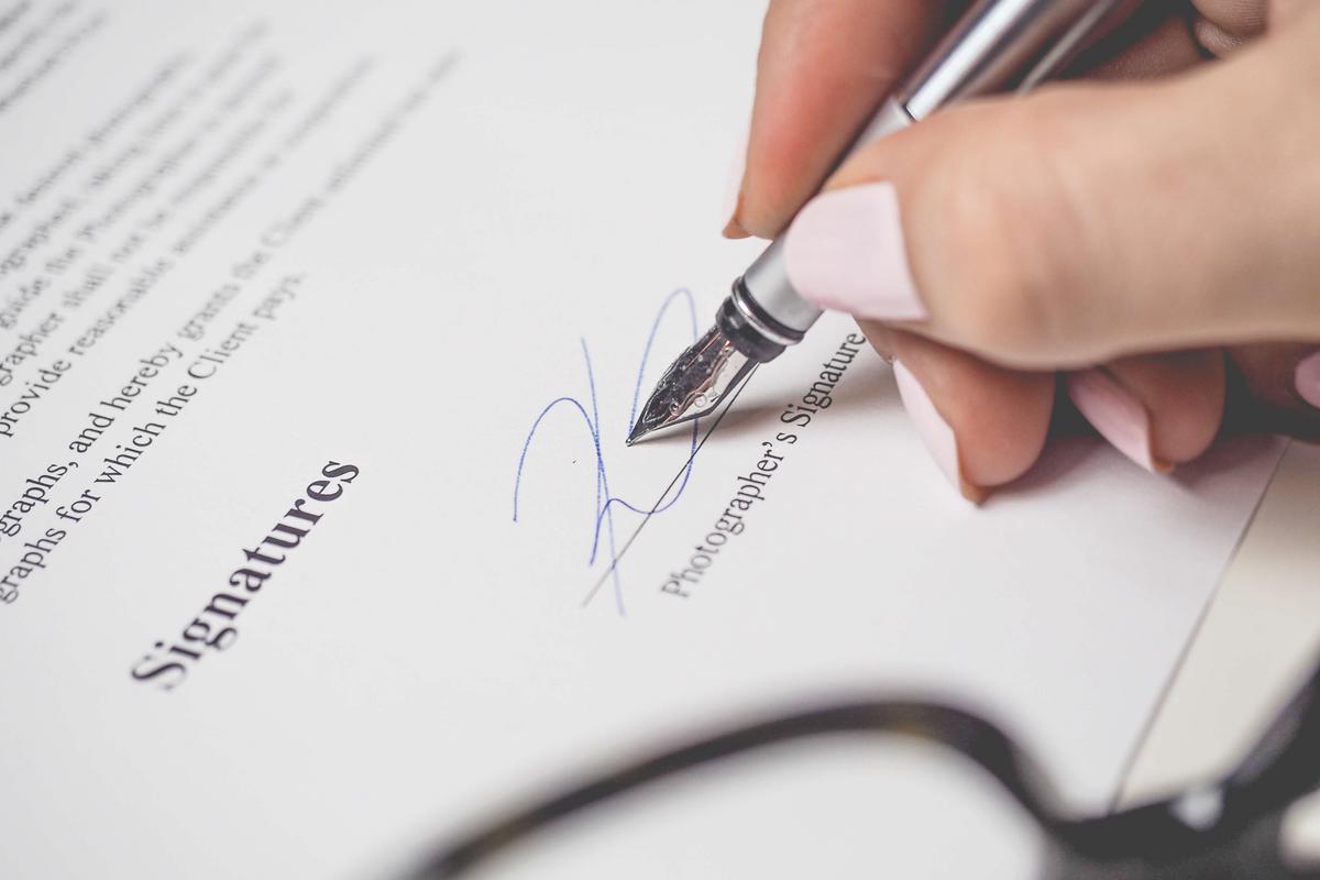 Main signant un contrat au stylo plume